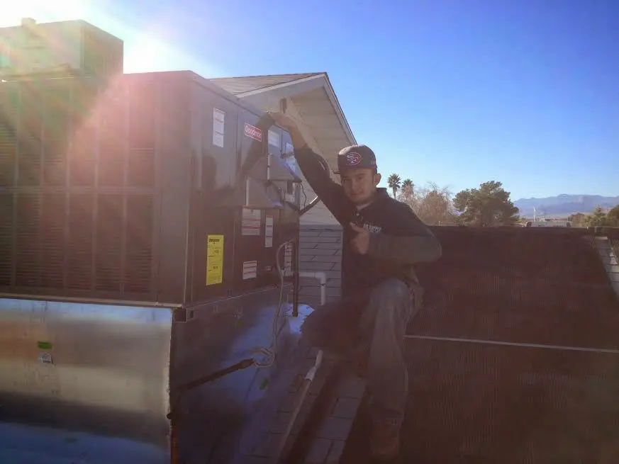 HVAC technician performing AC Tune-Up on a rooftop unit in Wyoming